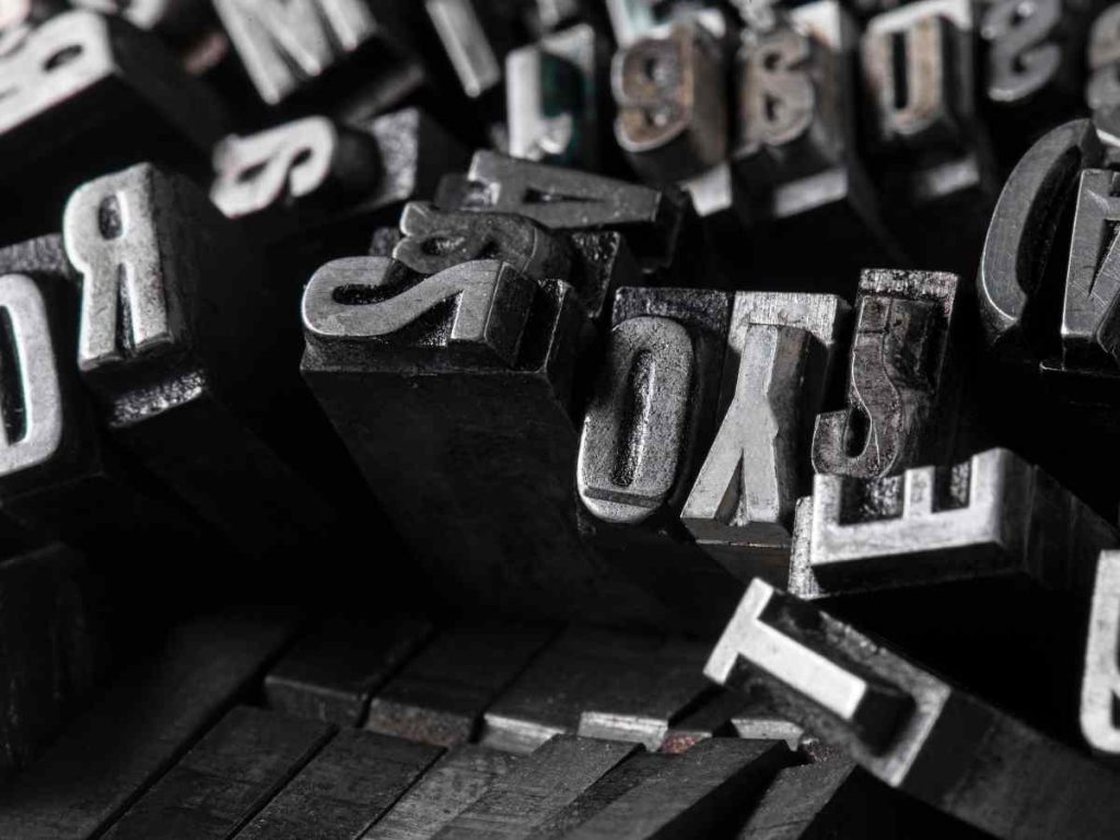 Tipos de letra en bloques metálicos utilizados en impresión, ilustrando elecciones tipográficas