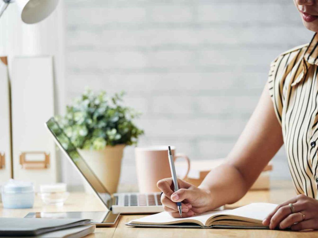 Alumno preparando su Trabajo de Fin de Grado en un escritorio con ordenador y cuaderno